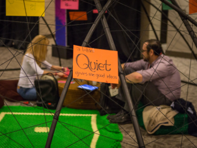 Close-up of a handwritten sign reading "a little Quiet gives me good ideas," inside the dome