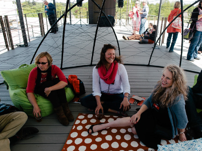 Three attendees laughing together inside the dome at TEDxMtHood, Revolution Hall