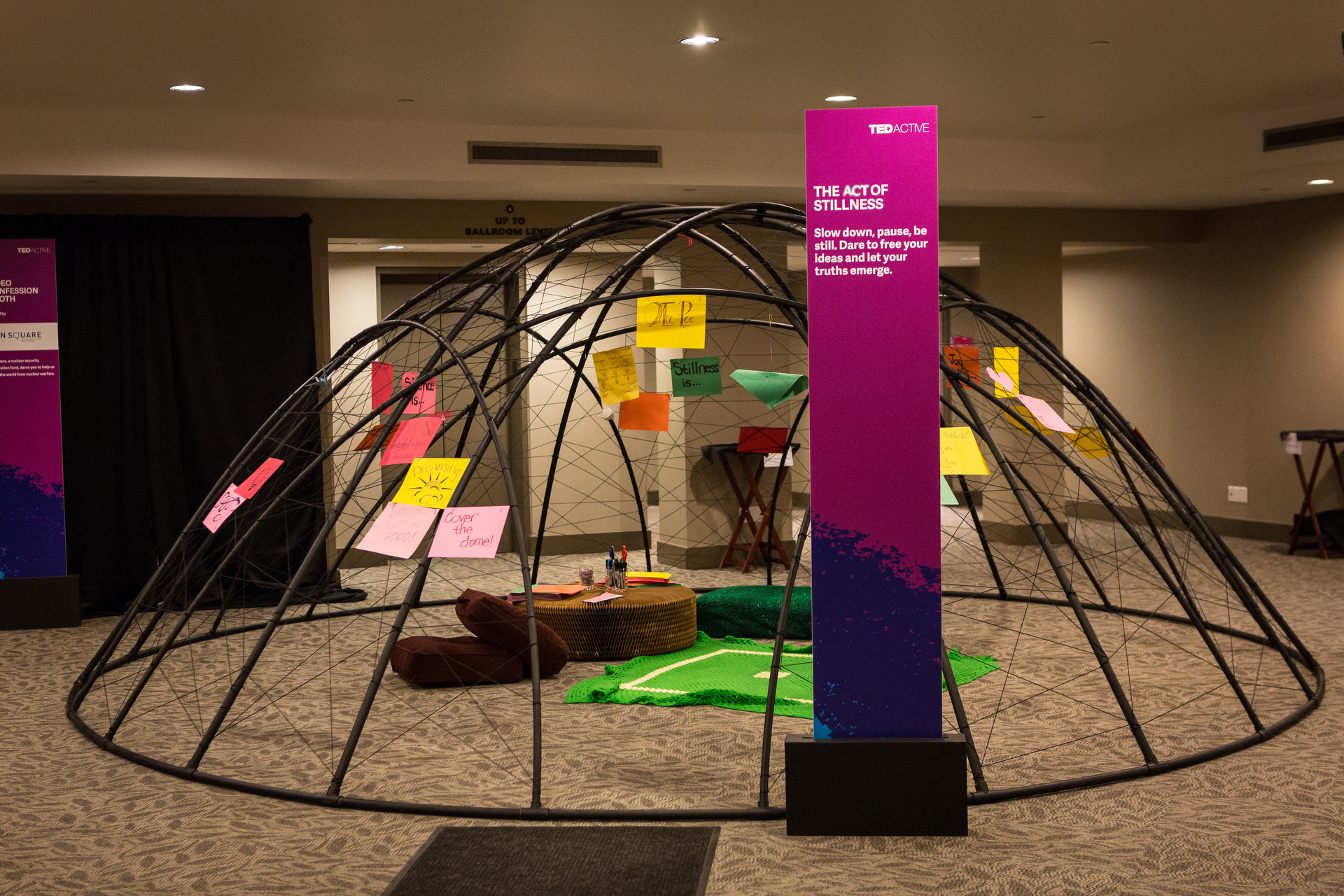 The Act of Stillness dome installed at TEDActive, with signage and colorful handwritten notes attached to the frame
