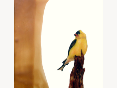 Encaustic painting of an American goldfinch perched on a branch, set against a warm amber ground.